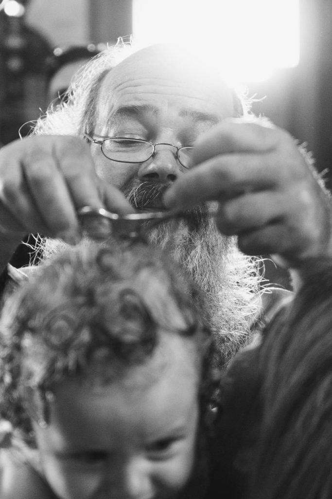 Martinos Petzolt schneidet einem Täufling die Haare
