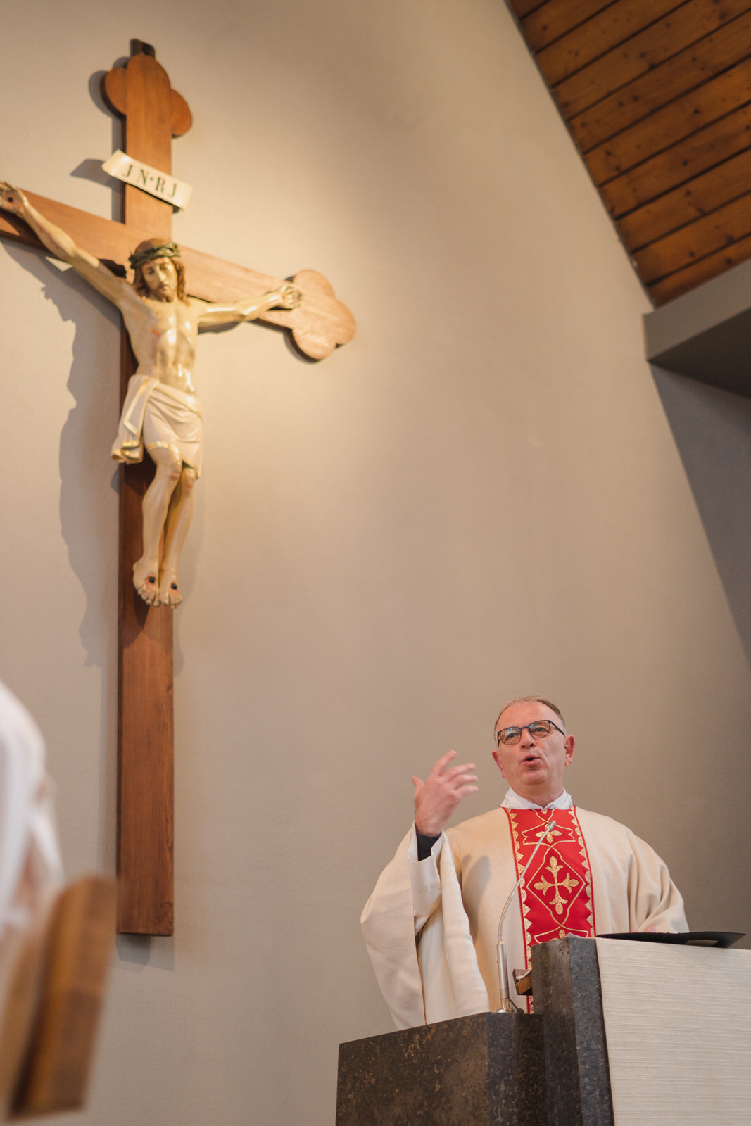 Pfarrer vor einem Kreuz während der Predigt